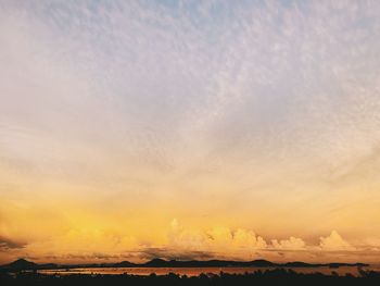 Scenic view of dramatic sky over land during sunset
