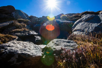 Scenic view of rocks against sky on sunny day