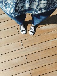 Low section of man standing on hardwood floor