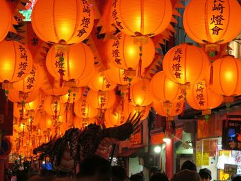 Illuminated lanterns hanging in store