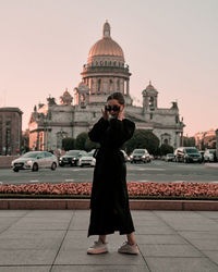 Rear view of woman standing against church