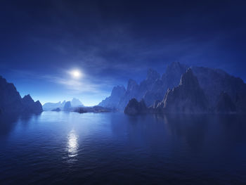 Scenic view of sea and mountains against blue sky