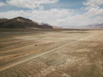 Scenic view of desert against cloudy sky