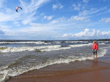 People on beach by sea against sky