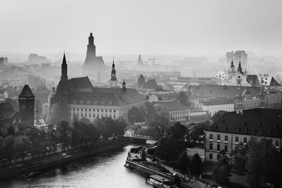 Townscape by river during foggy weather