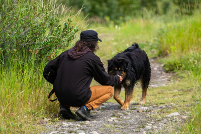 Rear view of woman with dog on street