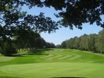 Scenic view of golf course against clear sky