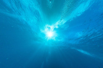 Low angle view of blue sea on sunny day