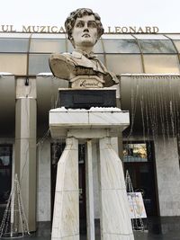 Low angle view of statue against built structure