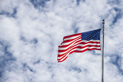 Low angle view of american flag against sky