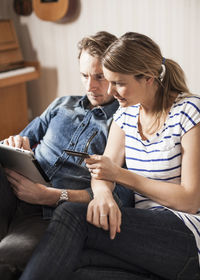 Couple shopping online with credit card and digital tablet at home