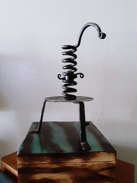 Close-up of electric lamp on table against wall