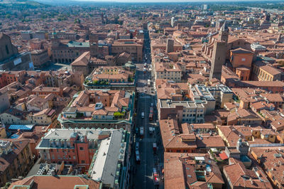 Aerial view of red tiled rooftops and street with traffic in bologna, italy. 
