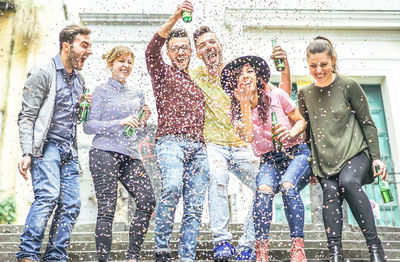 Cheerful male and female friends enjoying party during sunny day