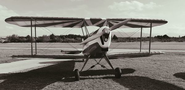 Man sitting on chair on field against sky