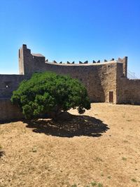 Surface level of fort against clear blue sky