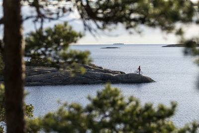 Man standing on cape with bicycle