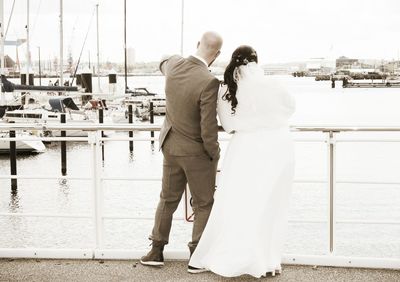 Rear view of couple standing at harbor