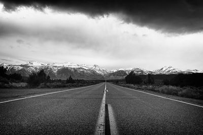 Country road against cloudy sky