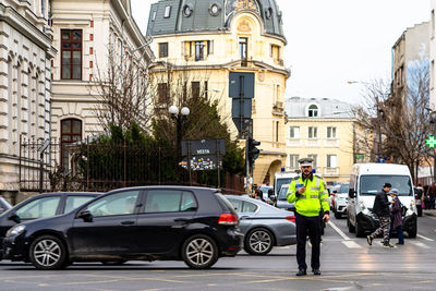 Vehicles on road amidst buildings in city