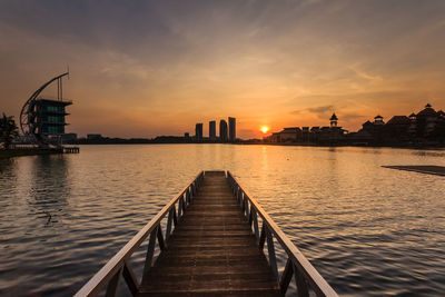 Pier over sea against sky during sunset