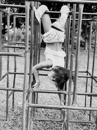 Rear view of girl playing on slide at playground