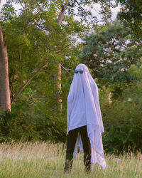 Rear view of woman standing on field