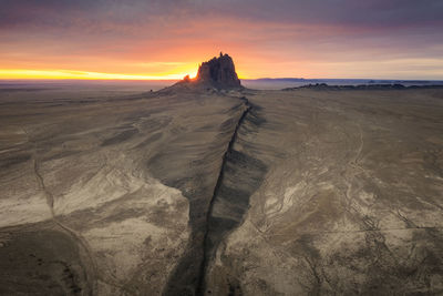 Scenic view of shiprock, nm against sky during sunrise