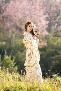 Full length of woman standing by flowering plants