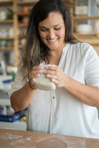 Woman kneading clay to make pottery