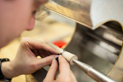 Man polishing wedding ring on table in workshop