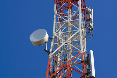 Low angle view of communications tower against clear blue sky