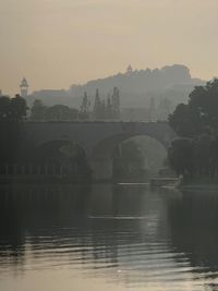 Bridge over river against sky during sunset