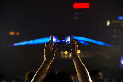 People photographing illuminated music concert at night