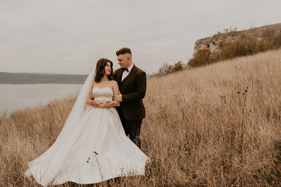 Rear view of couple standing on field