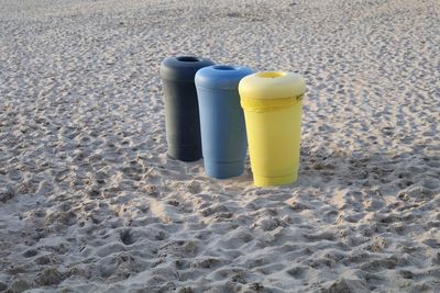 High angle view of colorful garbage bins on sand