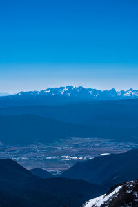 Scenic view of snowcapped mountains against blue sky