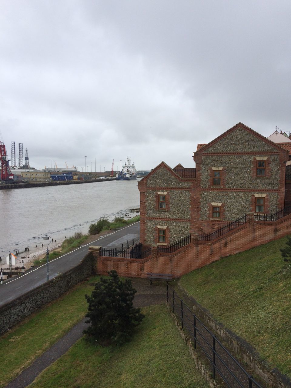 architecture, built structure, building exterior, sky, water, river, cloud - sky, grass, bridge - man made structure, connection, cloudy, city, cloud, day, outdoors, transportation, no people, travel destinations, the way forward, canal