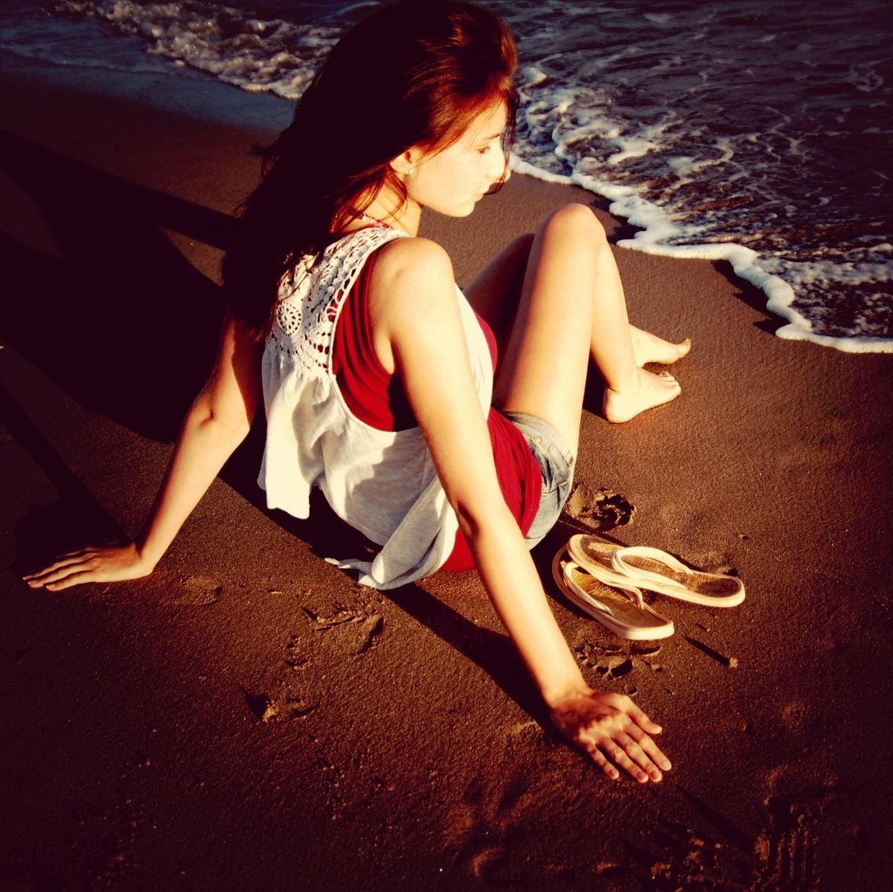 beach, childhood, lifestyles, leisure activity, full length, water, high angle view, sand, sitting, shore, relaxation, girls, sea, person, elementary age, sunlight, barefoot, vacations