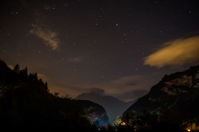 Scenic view of silhouette mountains against sky at night