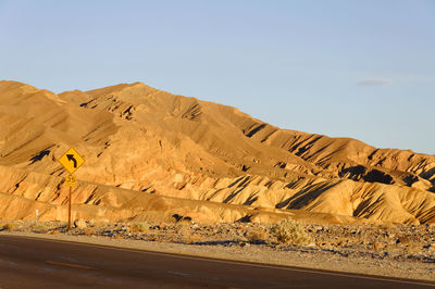 Scenic view of desert road against clear sky