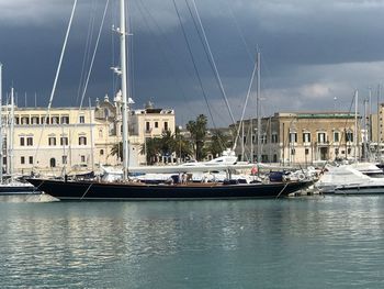 View of marina at harbor against cloudy sky