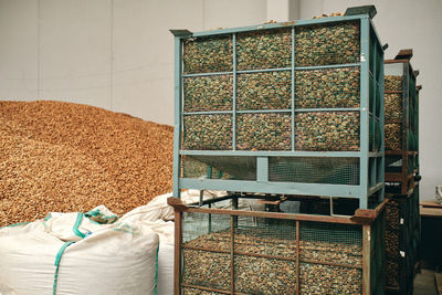 Grain crops in sacks and containers placed in bright spacious storehouse of factory
