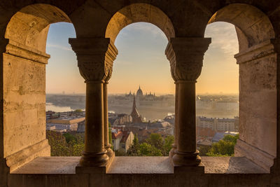 City seen through window during sunset