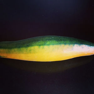 Close-up of lemon over water against black background