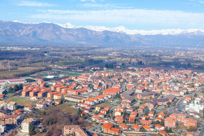 Flying over venaria from metropolitan city of turin . aerial view of turin suburbs and alps mountain