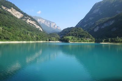 Scenic view of lake and mountains against blue sky