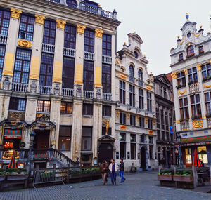 People walking on street amidst buildings in city