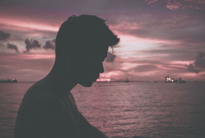 Portrait of silhouette man in sea against sky during sunset