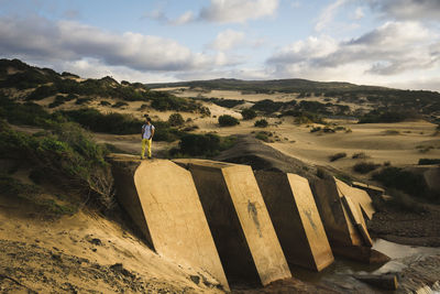 Scenic view of old dam with hiker and sand dunes of piscinas sardinia